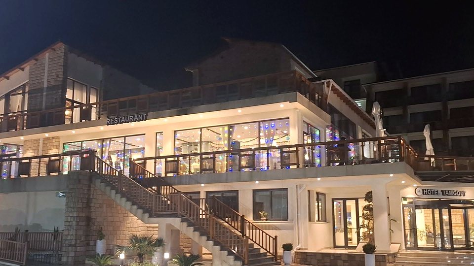 L’Hôtel Tamgout illuminé au crépuscule, au cœur de la forêt de Yakouren